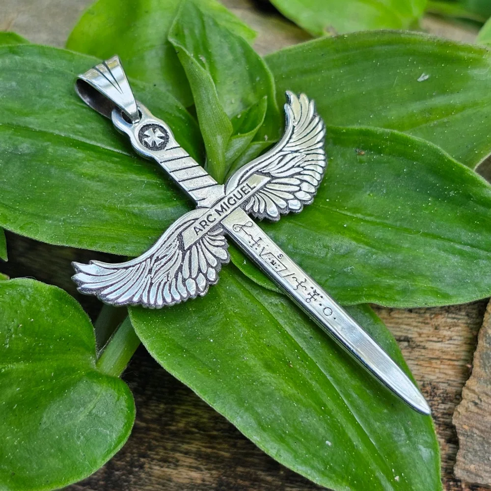 Colgante espada con alas Arc Miguel, sobre hojas